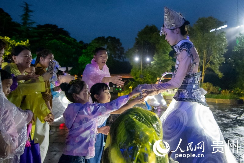 6月23日，游客夜游黃果樹瀑布，與表演人員互動。人民網記者 翁奇羽攝