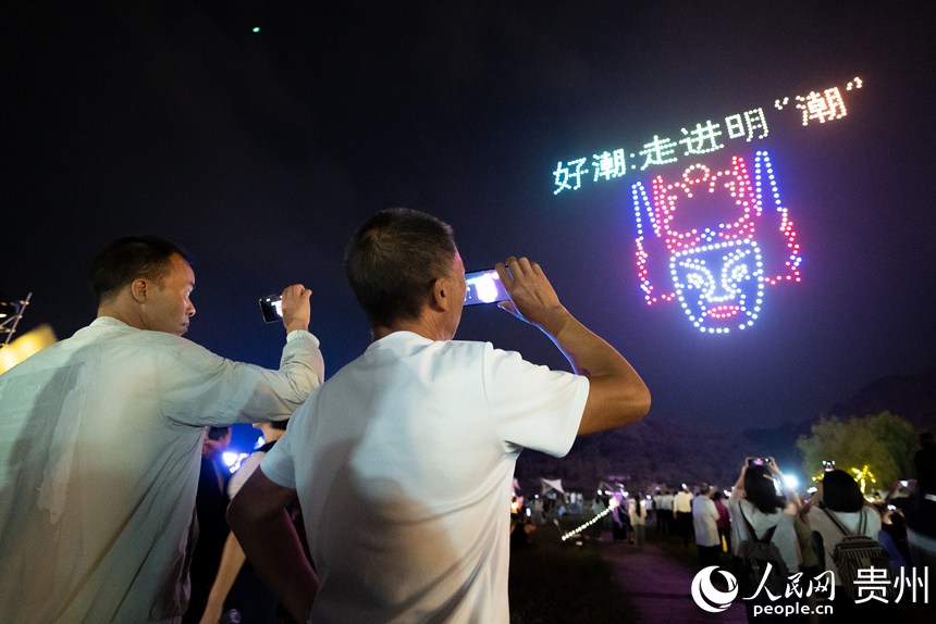 游客在云峰屯堡內觀看無人機燈光秀。人民網記者 涂敏攝