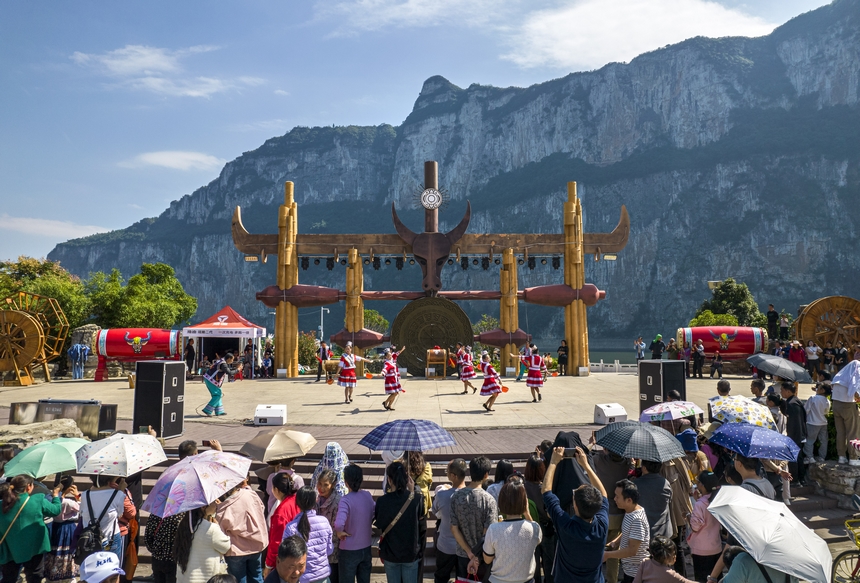 貴州省黔西市烏江源百里畫廊化屋景區，游客觀賞當地苗族村民表演原生態歌舞（無人機照片）。