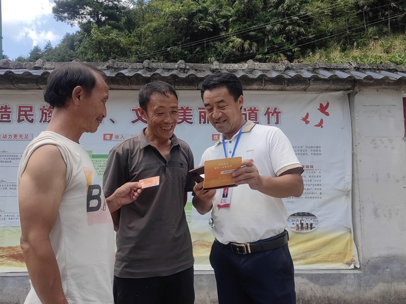 1、黃蓮鄉道竹村村干部向群眾核實卡號、兌現金額。