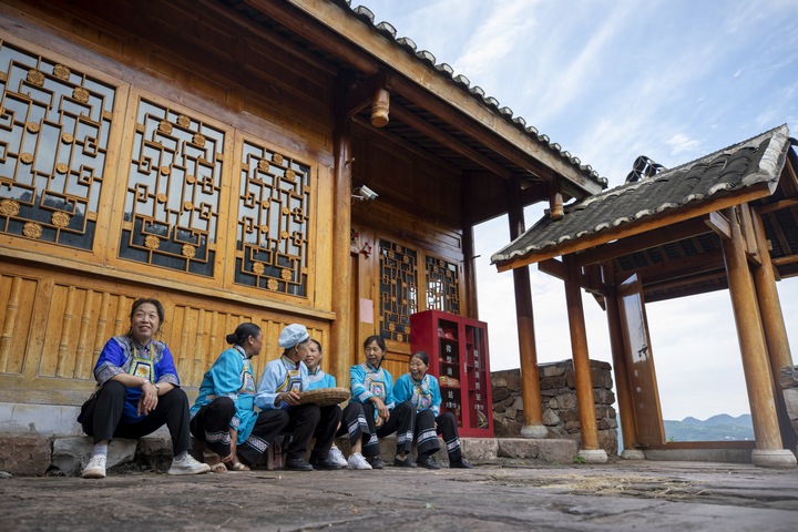 背坐村水族婦女在水族客廳前聊天。何志剛攝