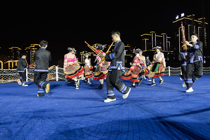 學生在貴州省黔南布依族苗族自治州羅甸縣玉湖公園水上舞臺表演蘆笙舞。 