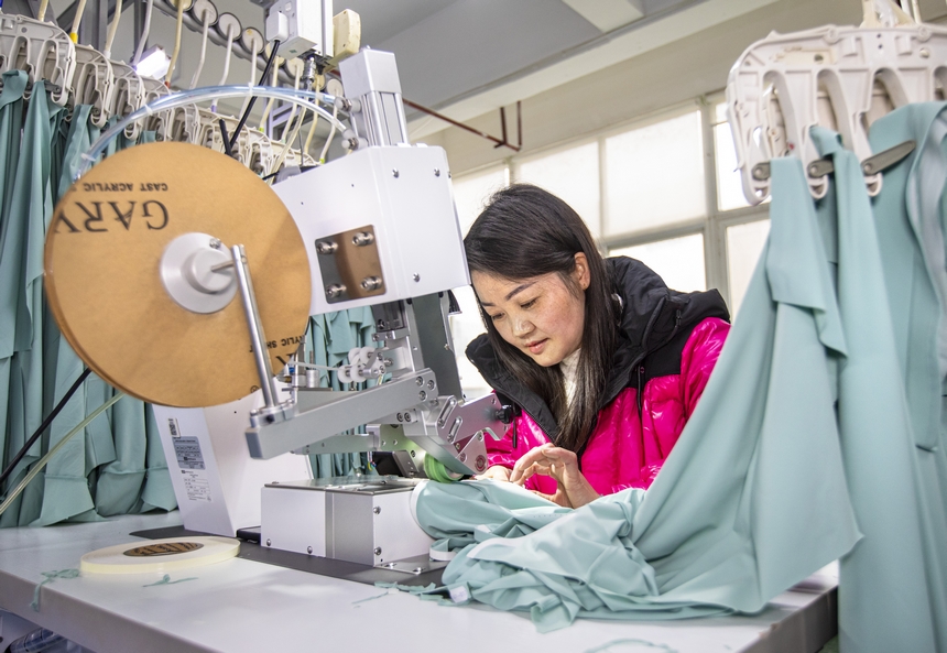 2025年2月5日，工人在貴州省畢節市黔西市經濟開發區一家服飾企業車間生產線上作業。