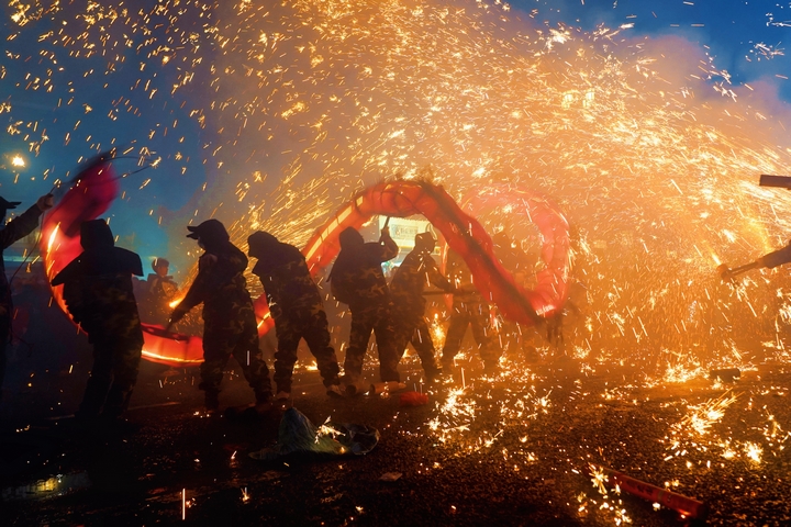 舞龍者在煙火中飛舞。