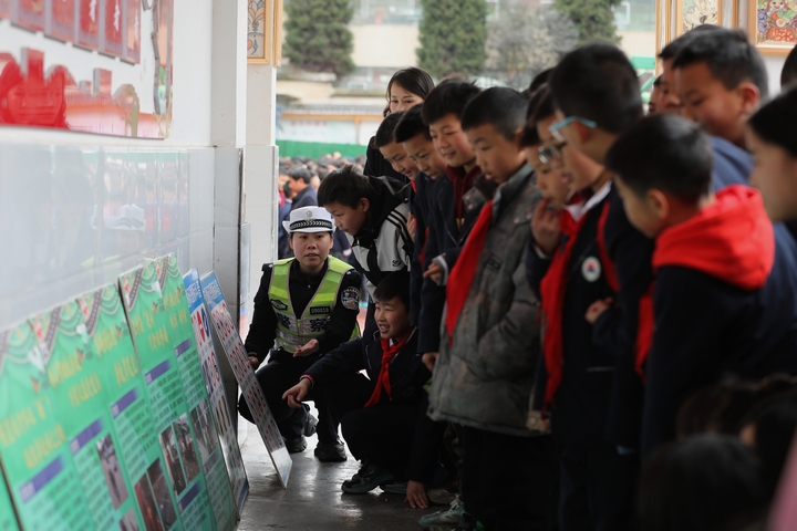圖為：2025年2月17日，雷山縣公安局交警大隊輔警向學生講解宣傳展板1.JPG