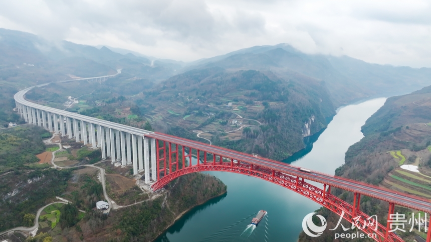 在烏江上航行的航電657號貨船與德余烏江特大橋同框。人民網記者 涂敏攝