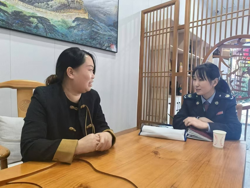 圖為六枝特區稅務局首席稅費服務專員上門宣傳優惠政策。張群攝