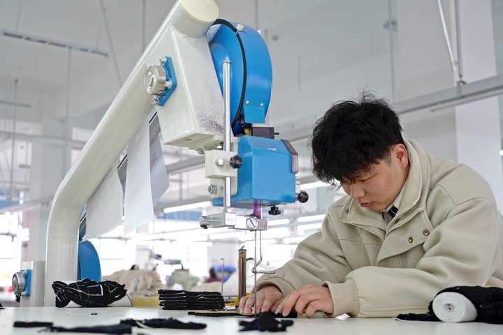 2025年2月25日，位于貴州省畢節市納雍縣工業園區的貴州博澤服裝有限公司生產車間，工人在趕訂單。   楊英 攝.jpg