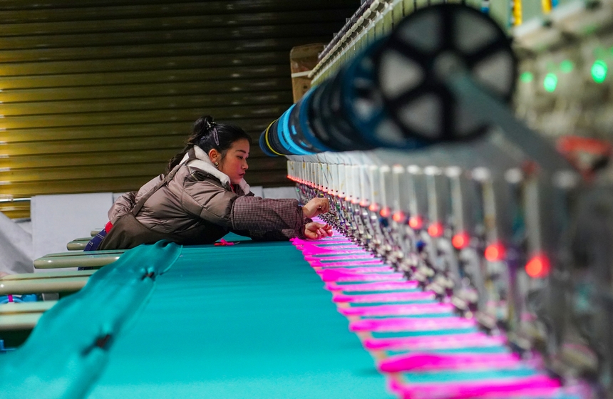 在貴州省從江縣美娥社區一家民族刺繡企業生產車間，工人在用數控機床生產刺繡產品。