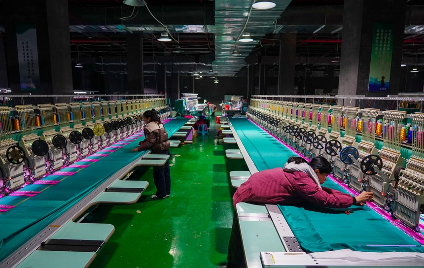 在貴州省從江縣美娥社區一家民族刺繡企業生產車間，工人在用數控機床生產刺繡產品。