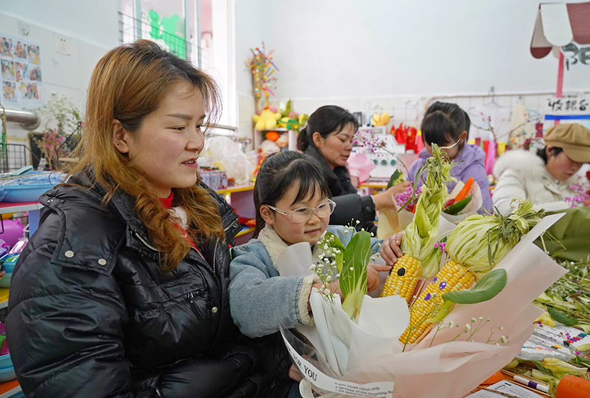2025年3月6日，貴州省畢節市納雍縣龍場鎮中心幼兒園“溫情三八·感恩有您”活動現場，家長和孩子們一起做手工。  楊  英 攝
