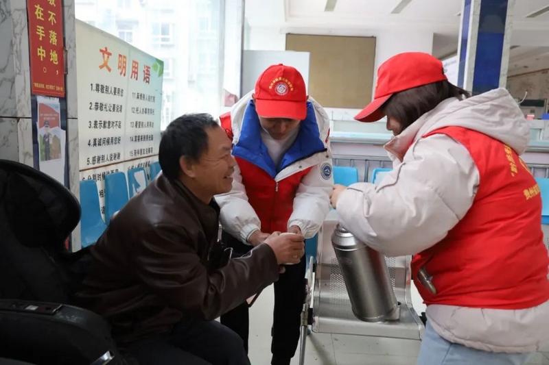志愿者給群眾倒熱水。
