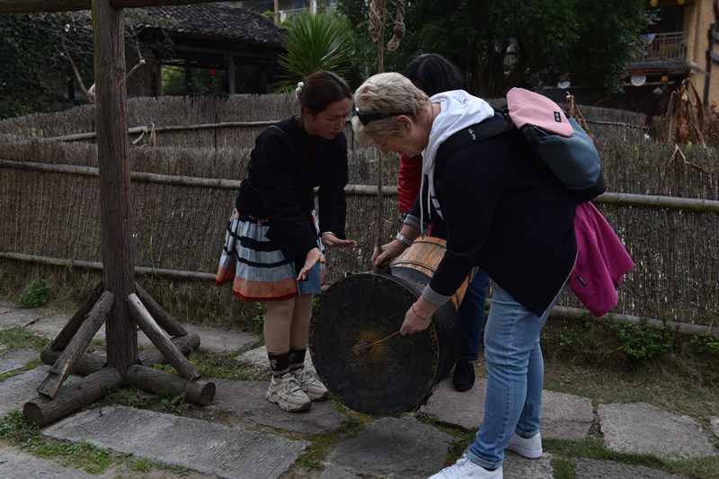 圖為德國游客體驗瑤族銅鼓。