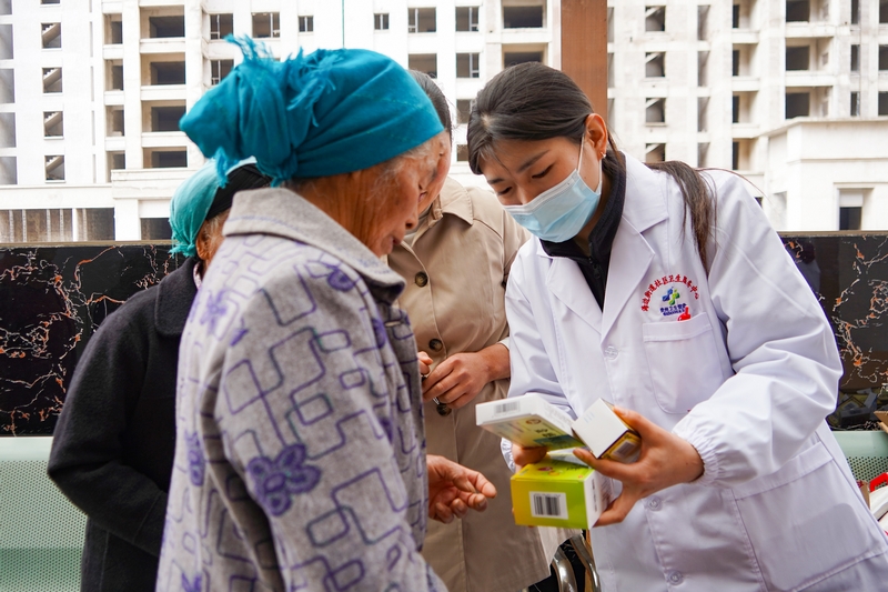 4月28日，在威寧自治縣海邊街道社區衛生服務中心，醫務人員給老人贈藥并說明藥的用法。