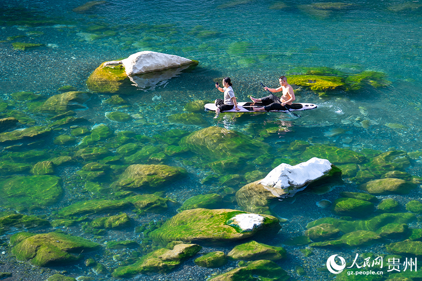 游客在清澈的河水中感受自然的樂趣。人民網記者 涂敏攝