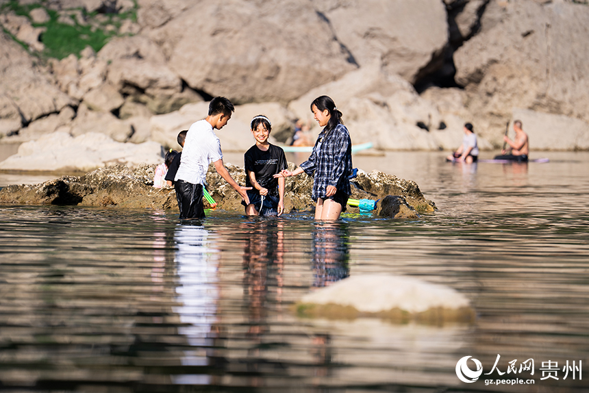 游客在淺灘處戲水嬉戲。人民網記者 涂敏攝