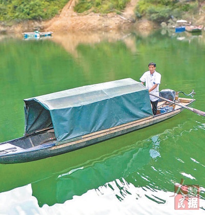 龍光慶在擺渡過河。姚晶權攝