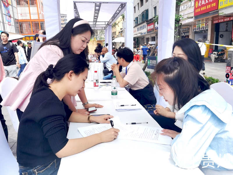 在青云市集的招聘攤位前，求職人員正在填寫信息。人民網記者 王秀芳攝