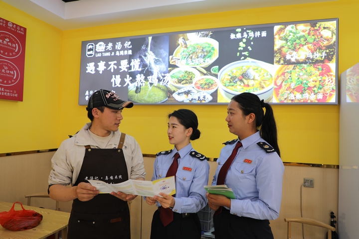 4 圖為普安縣稅務局“文旅服務專班”到景區周邊商超、餐飲等個體工商戶征詢涉稅服務需求，宣傳稅收優惠政策。張杉 攝.JPG