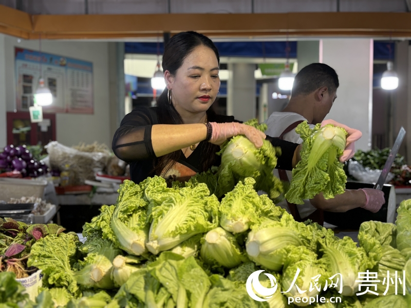 羅芬正在整理攤位上的蔬菜。人民網記者 高華攝