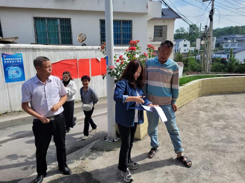 貓洞村的村支兩委干部走訪群眾。