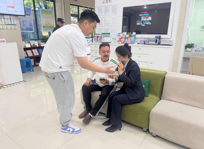 郵儲銀行黔東南州分行營業部業務人員借助中英文轉換APP與外籍客戶交流。