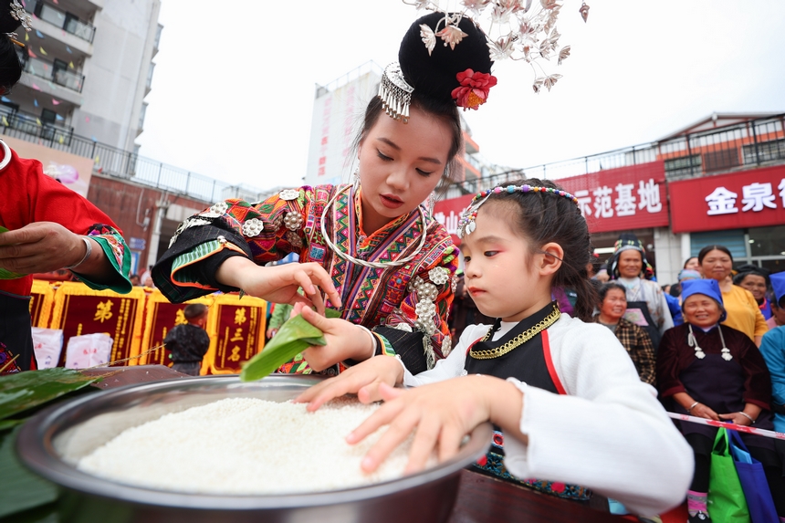 2025年5月29日，在貴州省丹寨縣金泉街道，身著傳統服飾的搬遷群眾在參加包粽子比賽。
