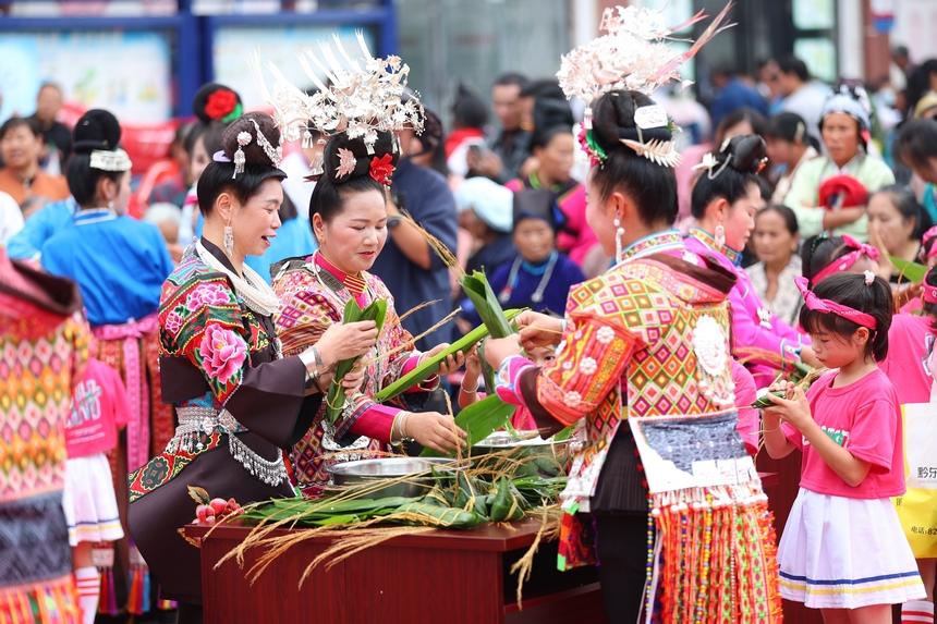 2025年5月29日，在貴州省丹寨縣金泉街道，身著傳統服飾的搬遷群眾在參加包粽子比賽。