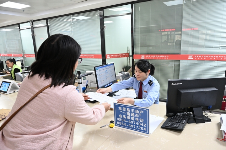 “一窗通辦”窗口工作人員為納稅人辦理不動產登記業務。