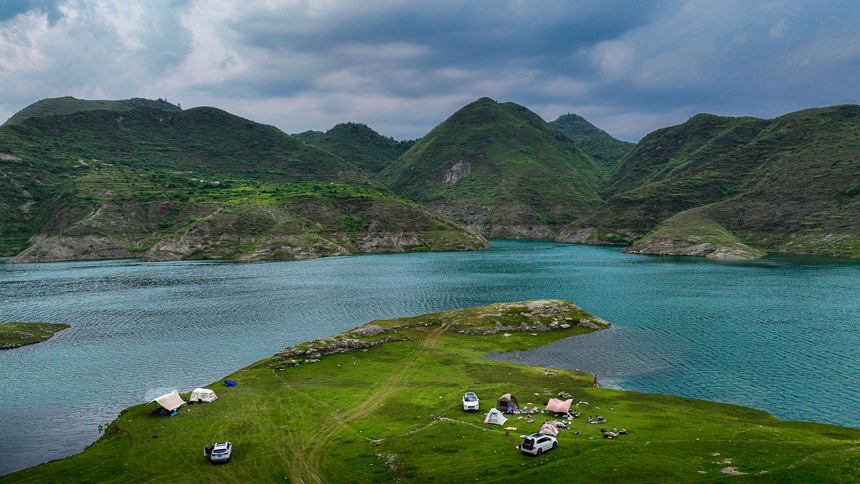 2025年6月14日，游客在在黔西市五里鄉桐山村境內的支嘎阿魯湖畔休閑觀光。