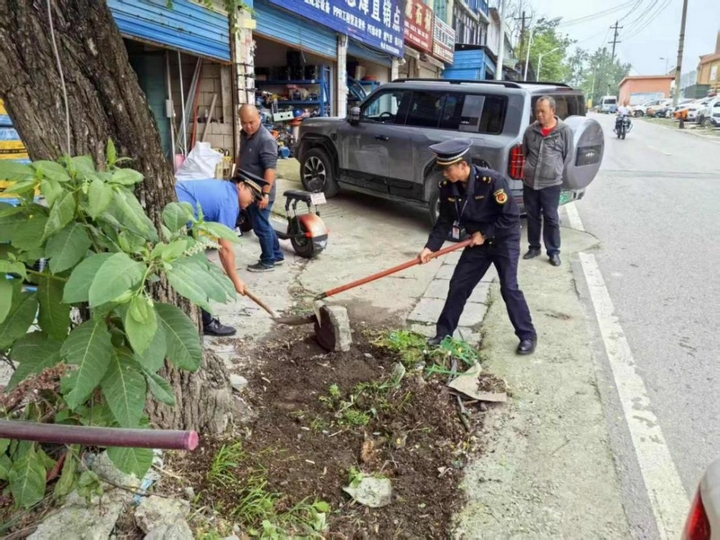 息烽縣綜合行政執法局工作人員在解放南路開展清理亂堆亂放工作.jpg