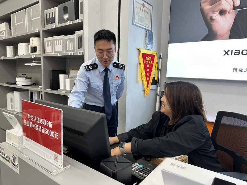 稅務干部輔導商鋪人員登錄電子稅務局系統操作。