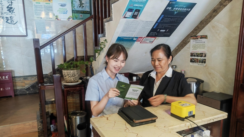 工作人員向個體商戶宣傳“陽光信貸”。