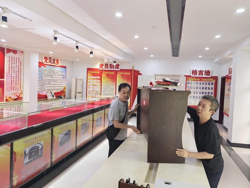 退休干部石碧玉同志（左一）與干部職工共同轉移單位底樓物資。