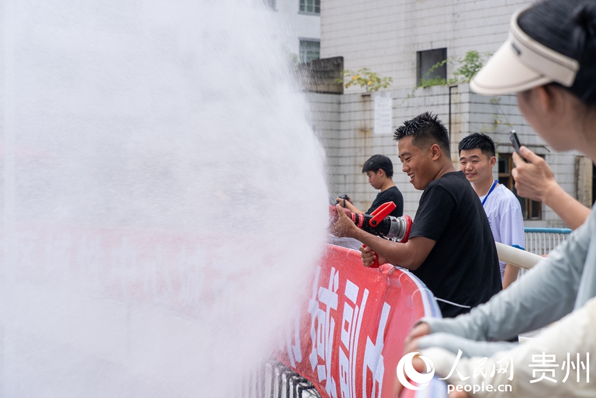 2025德江“水龍節”活動現場，工作人員為參加活動的市民游客灑水助興。人民網記者 涂敏攝