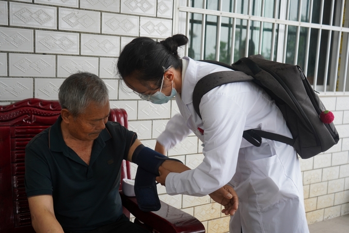 村醫正在給老人量血壓。黃源匯 攝.jpg