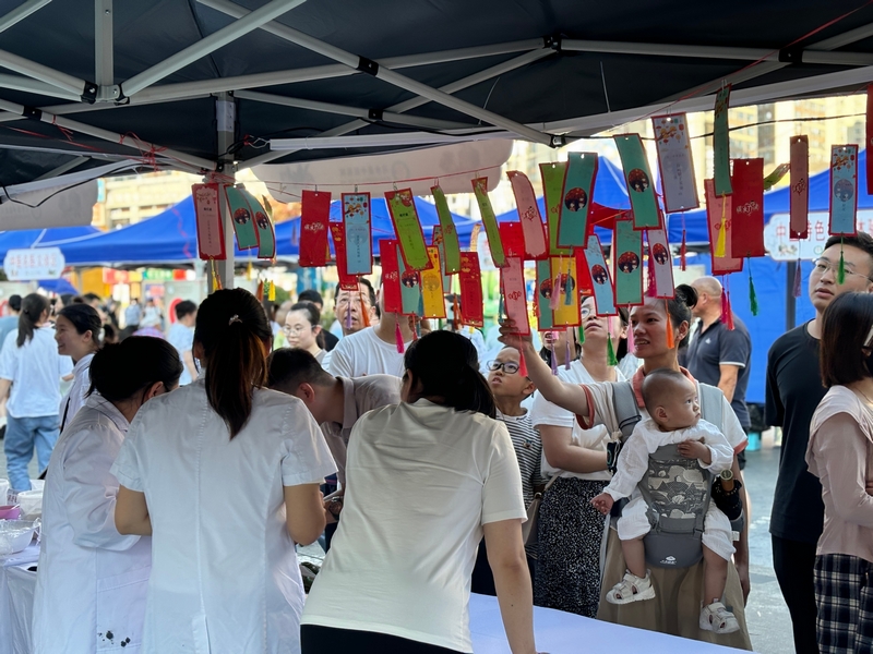 本草燈謎墻前市民猜謎互動。王燁攝