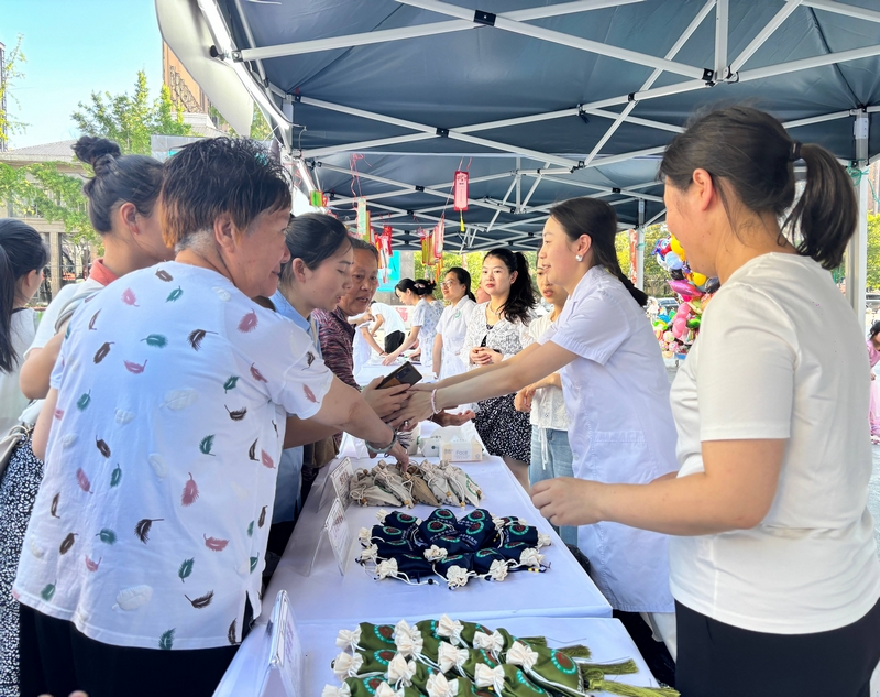 市民在攤位前領取中藥香囊。王燁攝