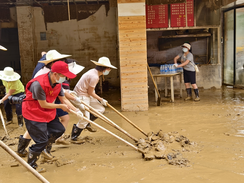 黔東南州局“黔稅先鋒”志愿隊伍支援榕江，圖為州局志愿者清理淤泥。