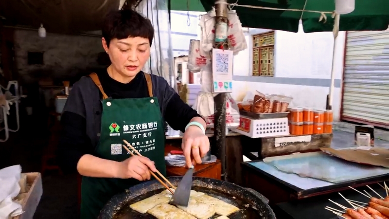 羅明菊在自家的攤位煎制六廣臭豆腐進行售賣。