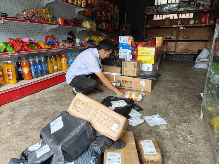 青山苗族鄉綠化村寄遞物流綜合服務站，店主正在整理快遞.jpg