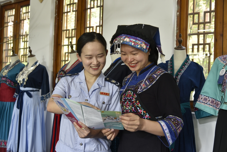 火把節期間，晴隆縣稅務人員走進“布依垚”服飾商鋪，為企業送去“稅費大禮包”，講解稅費政策。劉湘攝