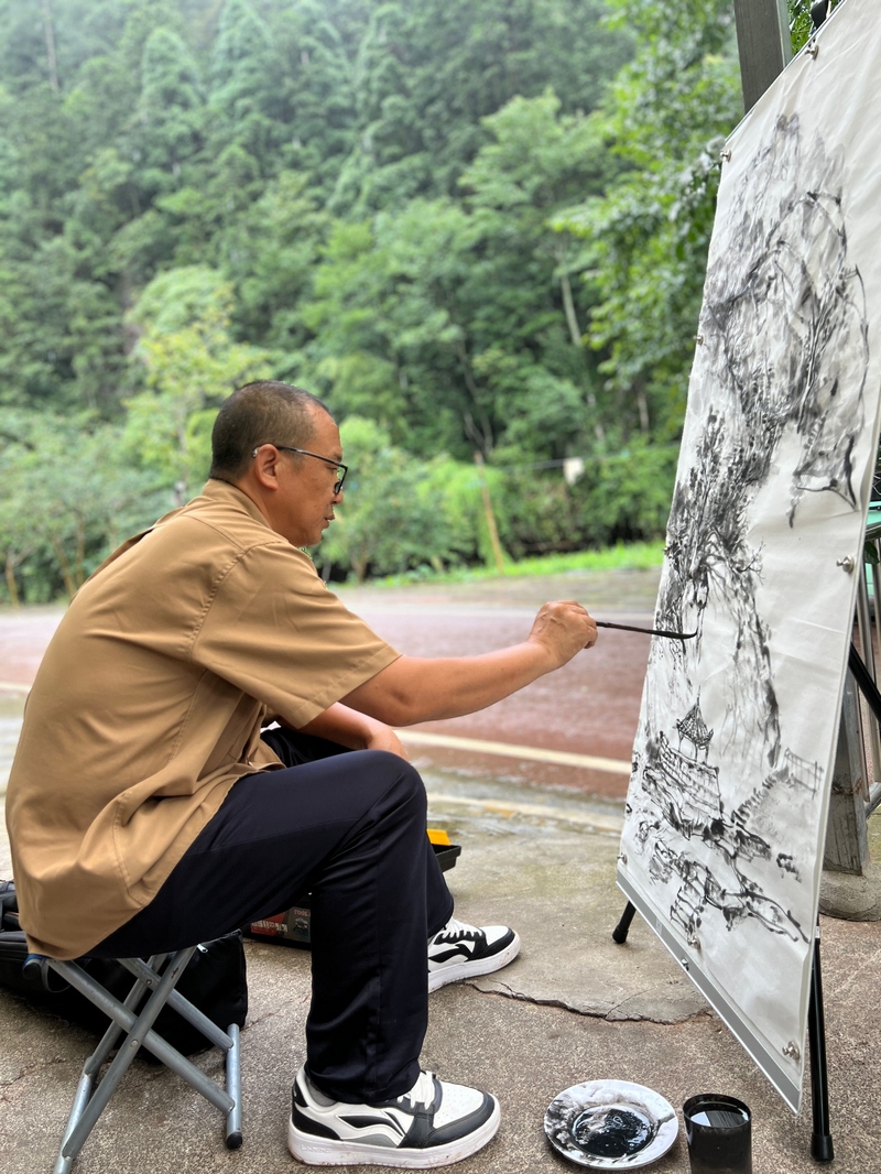 中國畫作品創作，以墨色勾勒丹霞谷山水輪廓。習水縣融媒體中心供圖
