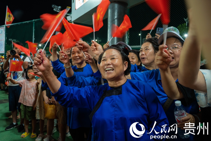 觀眾揮舞著紅旗為巡游隊伍喝彩。人民網 陽茜攝