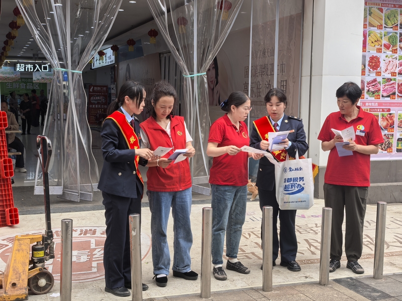 “枝己”志愿服務隊向超市員工講解稅費政策。胡凡銳攝
