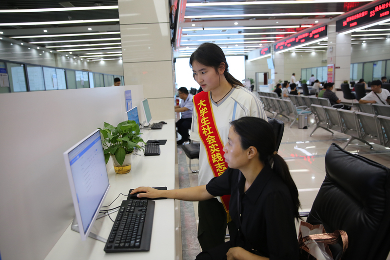 大學生志愿者在自助辦稅區輔導納稅人辦理涉稅業務。鄭婷攝