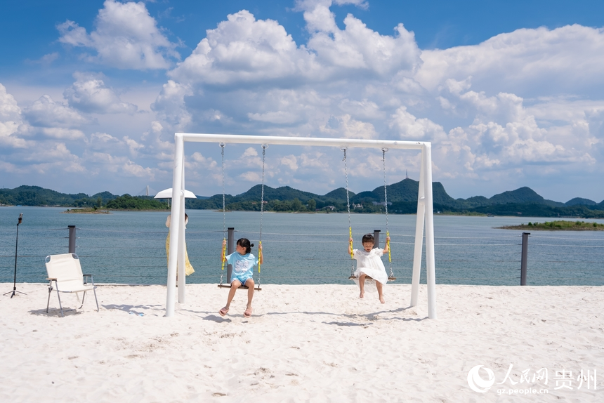 小朋友在湖邊露營基地的沙灘上嬉戲。人民網記者 涂敏攝