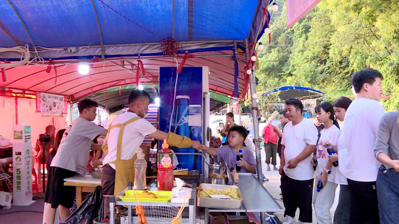 圖為小吃攤點前購買的食客。
