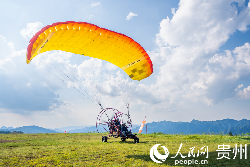 游客體驗動力滑翔傘飛行。人民網記者 涂敏攝
