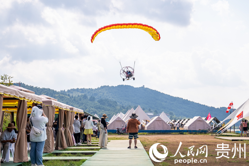 游客體驗動力滑翔傘飛行。人民網記者 涂敏攝